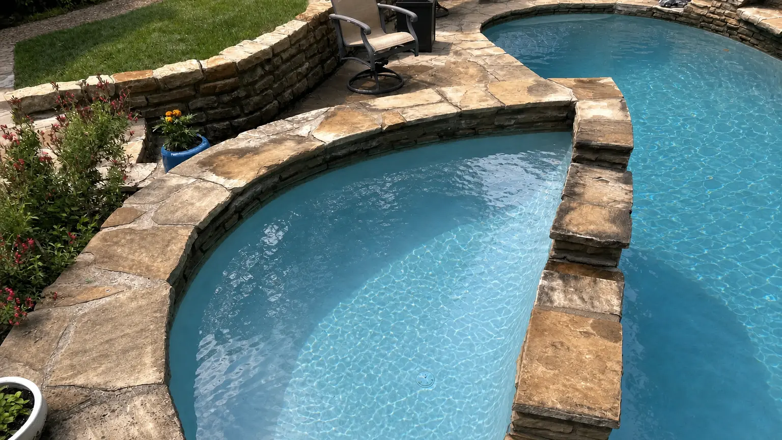 Clean landscaped pool with dark blue water after service